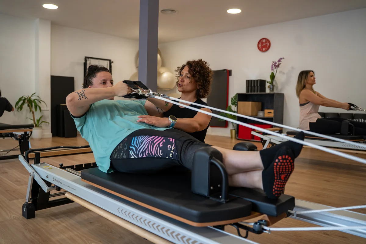 Sandra Bravo corrigiendo a una alumna en Reformer